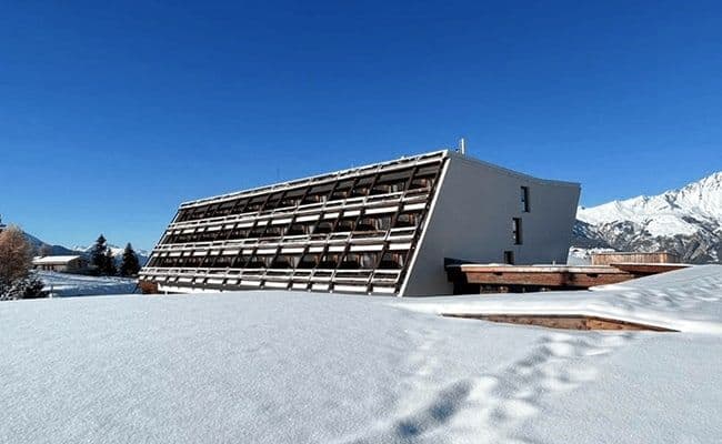 Apartment building exterior featuring tiered balconies and panoramic mountain views