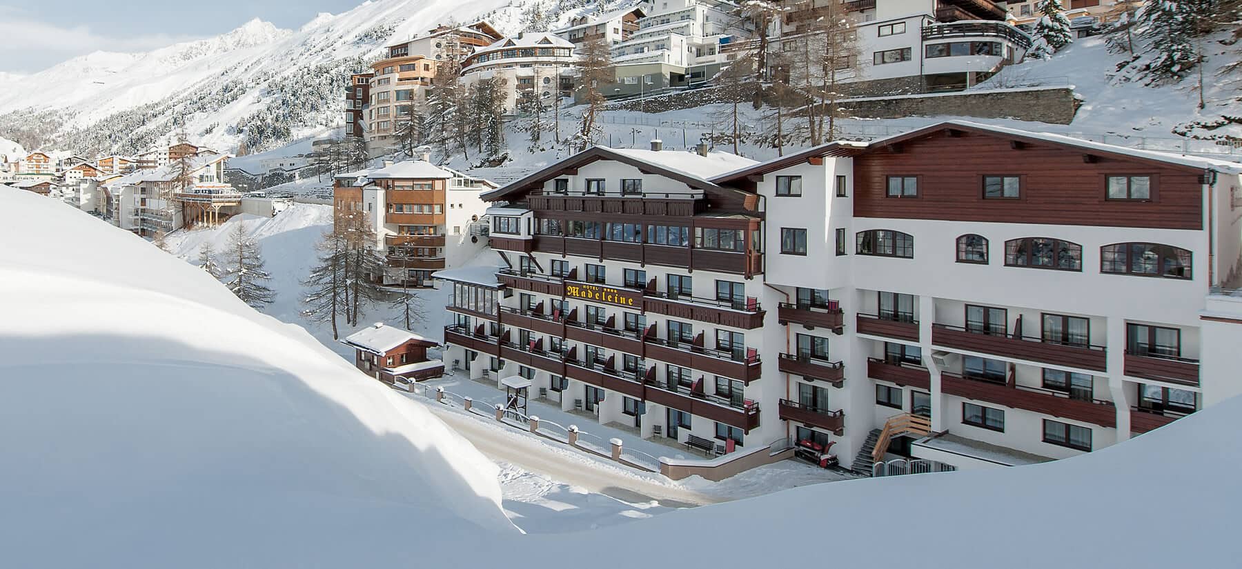 Ski-in/ski-out hotel exterior with private balconies and mountain views