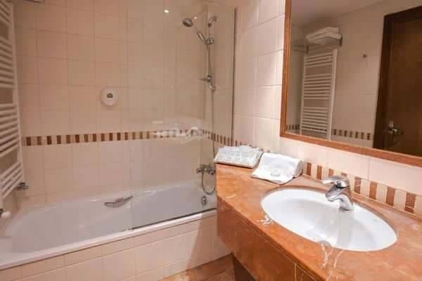 Bathroom with bathtub shower combo and heated towel rail