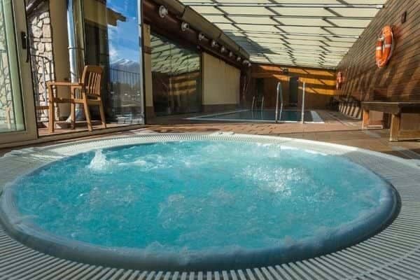Indoor hot tub and lap pool with retractable glass roof