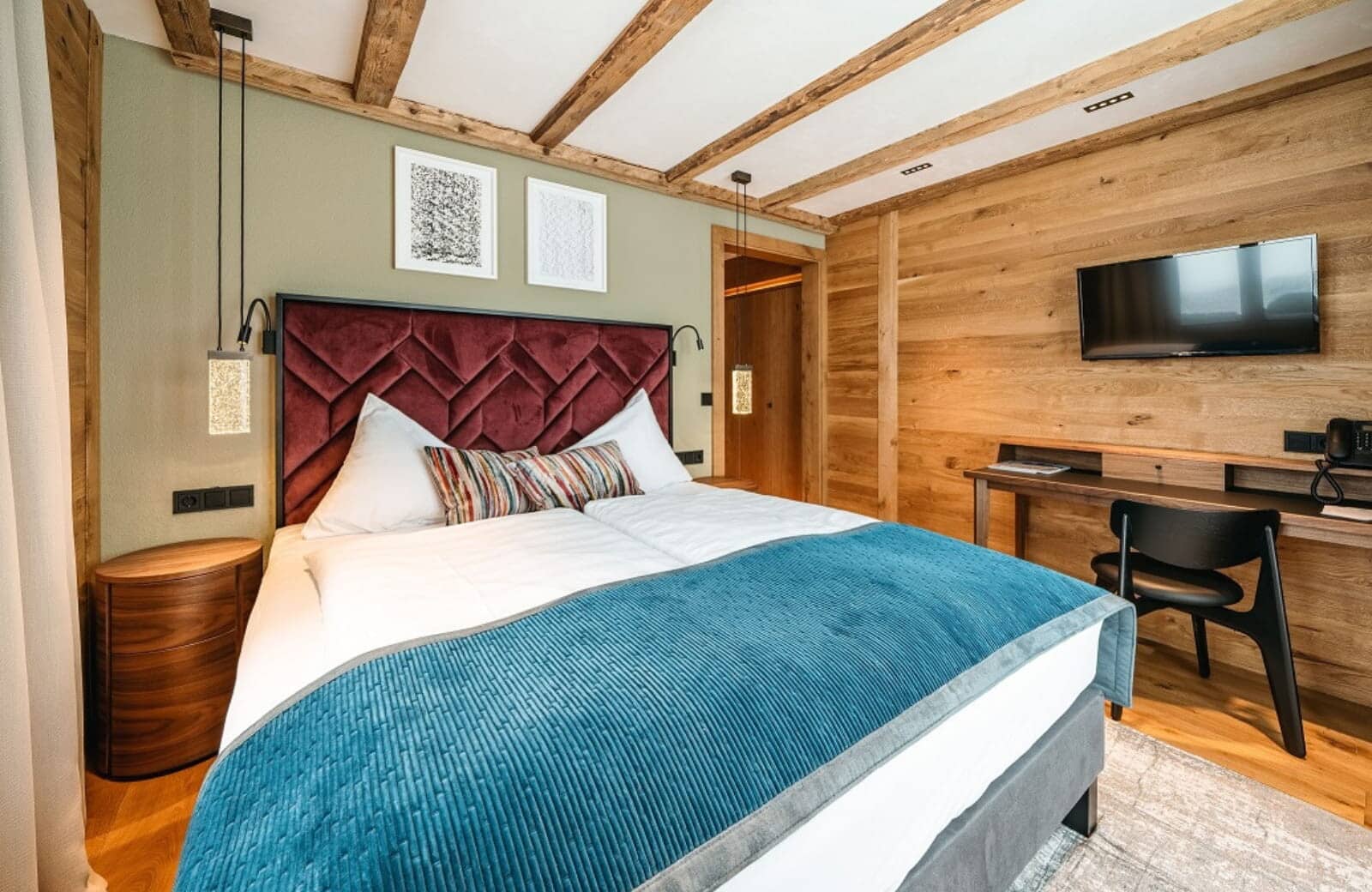 Guest bedroom with king bed, work desk, and wall-mounted TV
