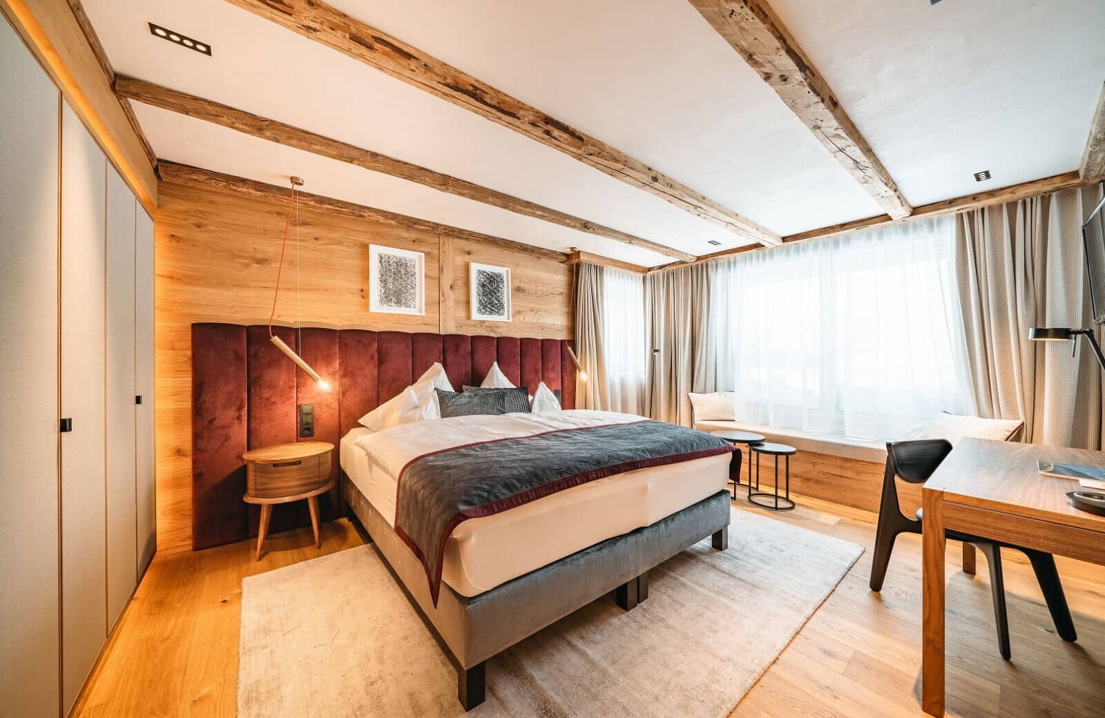 Bedroom with king bed, timber-beamed ceiling, and built-in workspace