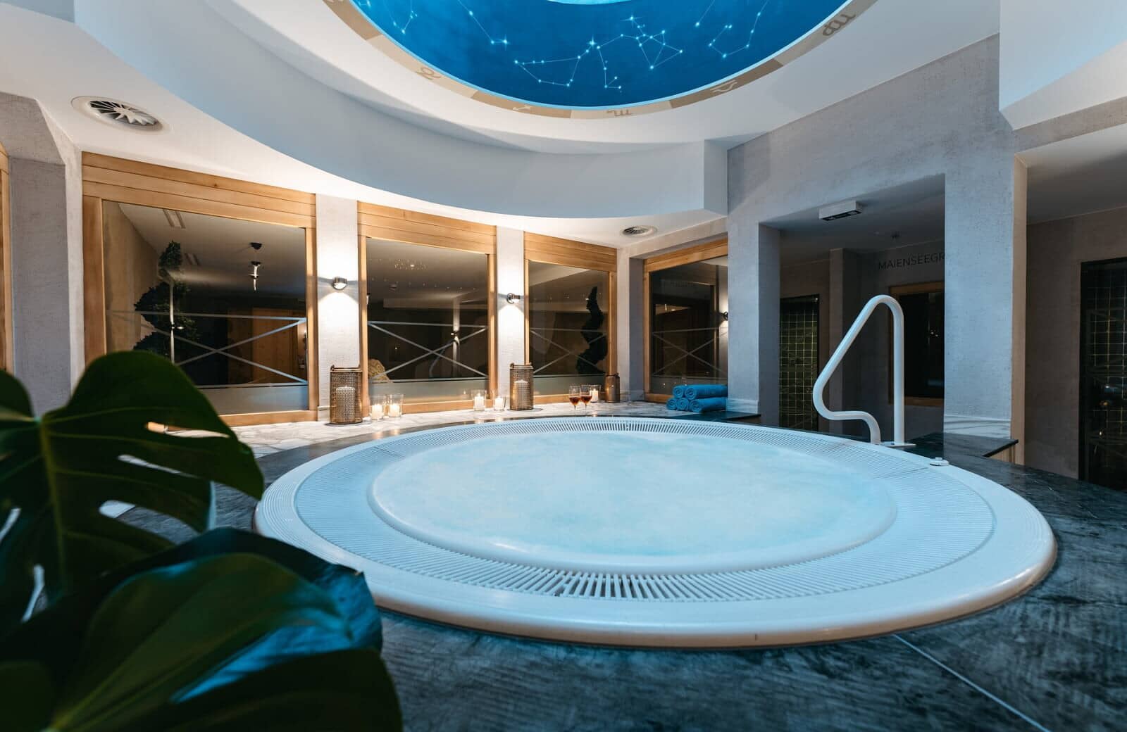 Indoor hot tub with handrail and constellation ceiling mural