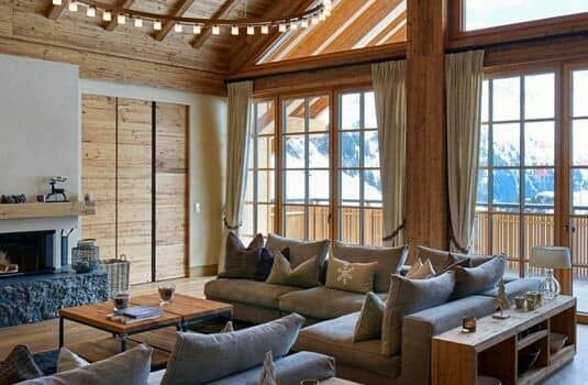 Living area with wood-burning fireplace and floor-to-ceiling mountain views