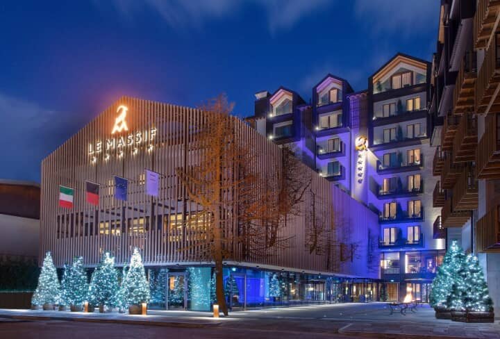Hotel exterior featuring private balconies and lit holiday trees