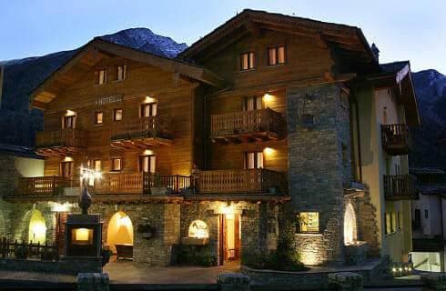 Stone and timber chalet with private balconies and mountain backdrop