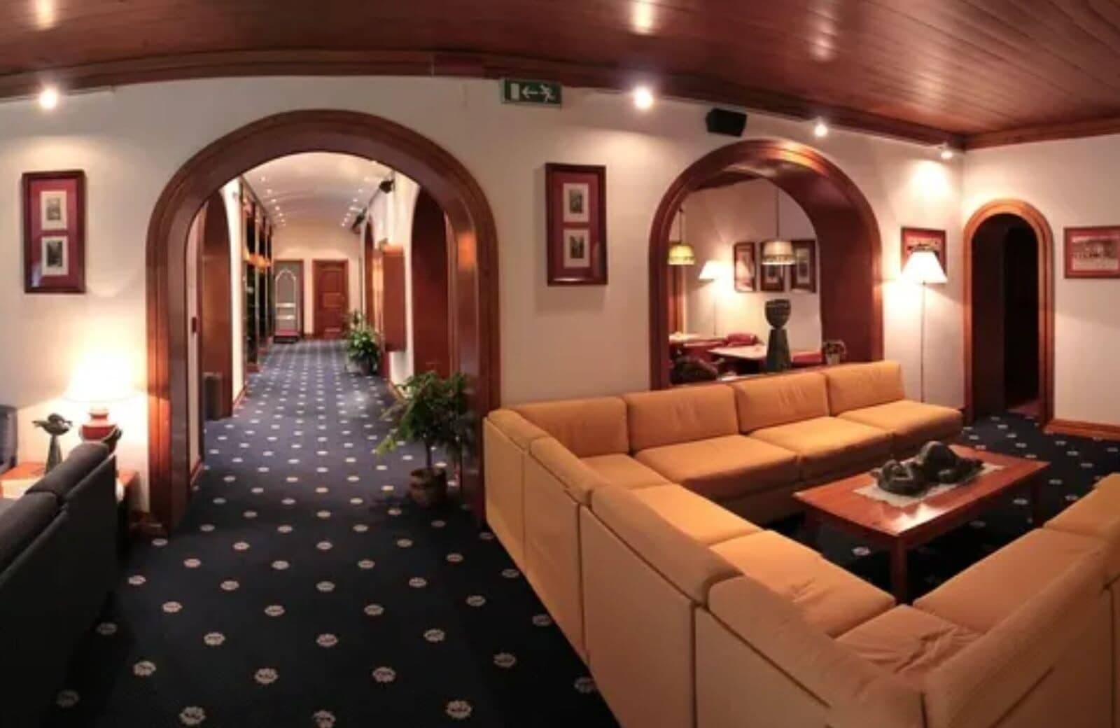 Lounge area with modular sectional seating and original wood-paneled ceilings