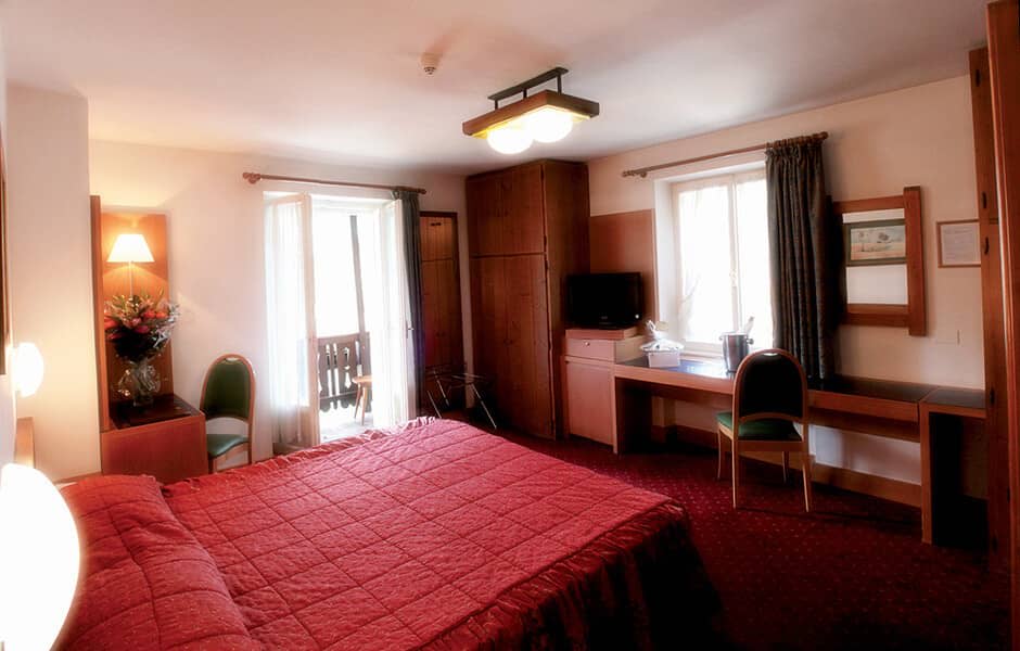 Guest bedroom with balcony access, work desk, and integrated wardrobe