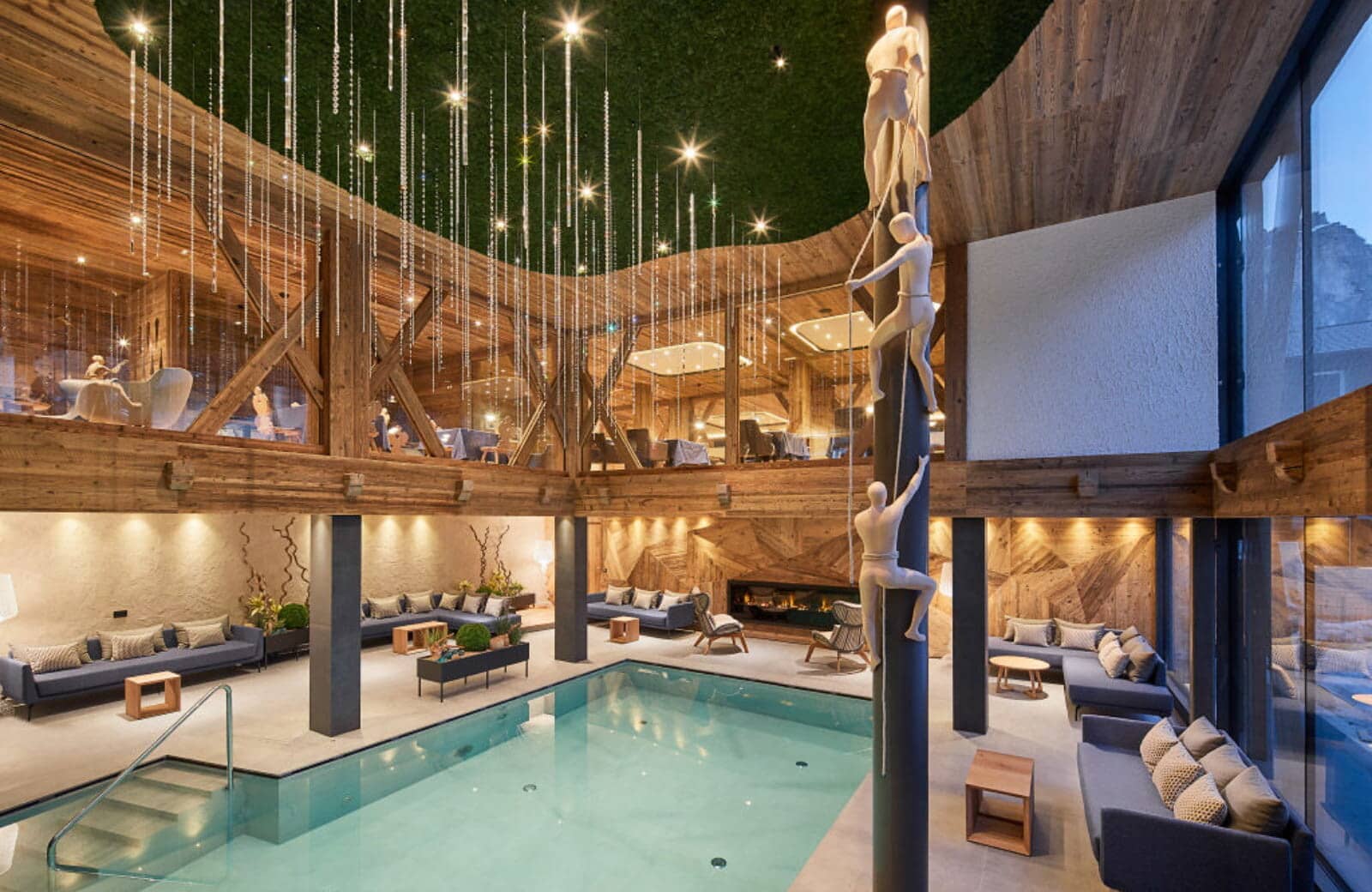 Indoor pool area with fireside lounge seating and mezzanine level above