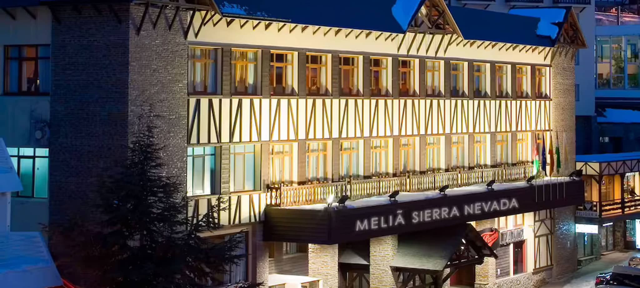 Meliá Sierra Nevada exterior with timber-frame facade and snowy surroundings