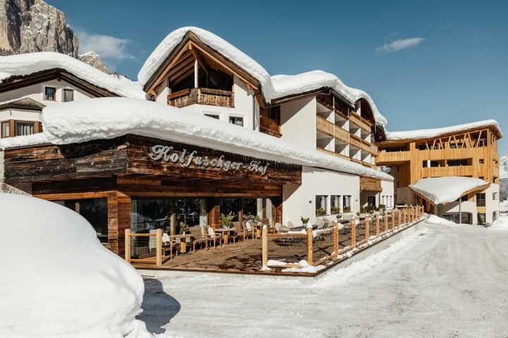 Ski-in/ski-out hotel exterior with outdoor dining terrace and mountain views
