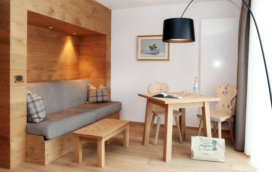 Seating area with wood-paneled alcove sofa and dining table for two