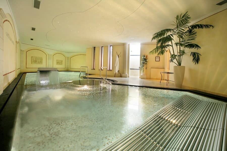 Indoor heated pool with waterfall feature and integrated whirlpool