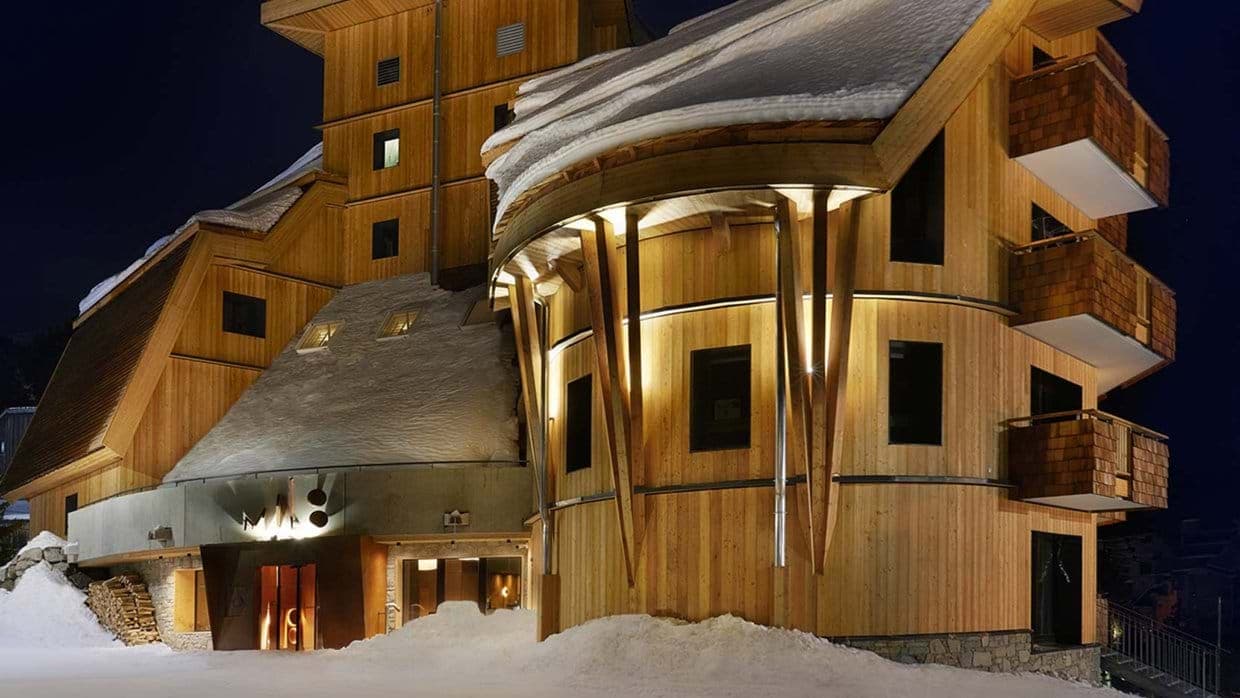Timber chalet exterior with private balconies and illuminated entrance
