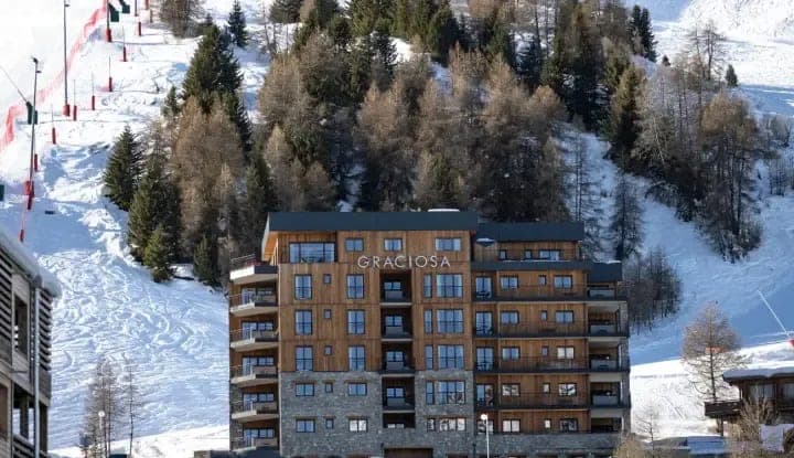 Ski-in/ski-out chalet exterior located directly adjacent to groomed piste
