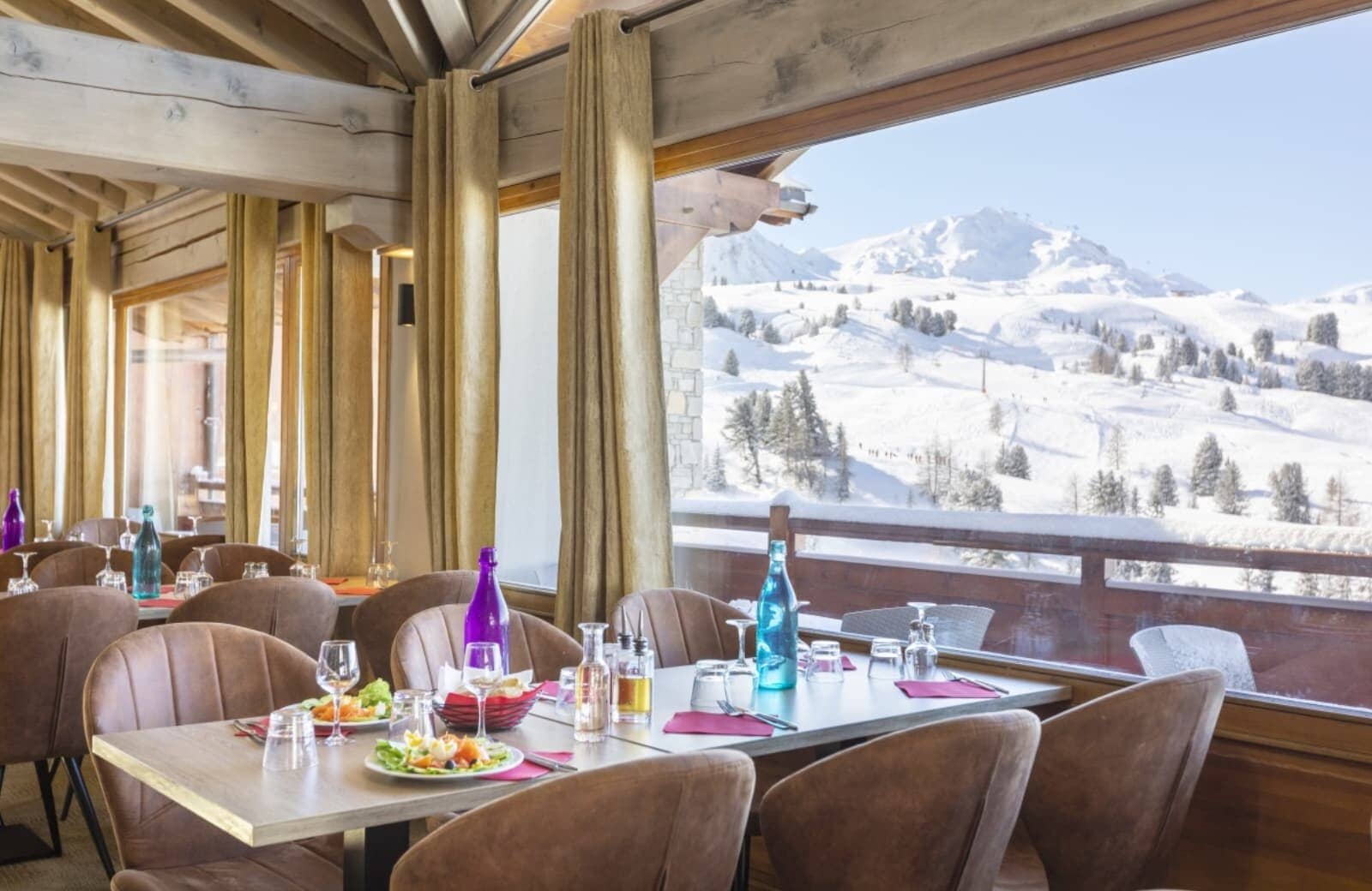 Dining area with panoramic windows overlooking snow-covered slopes