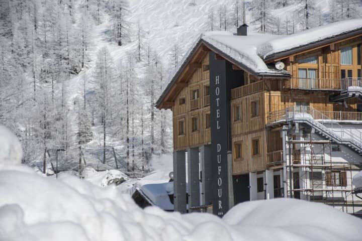 Ski-in/ski-out chalet exterior with timber cladding and mountain backdrop