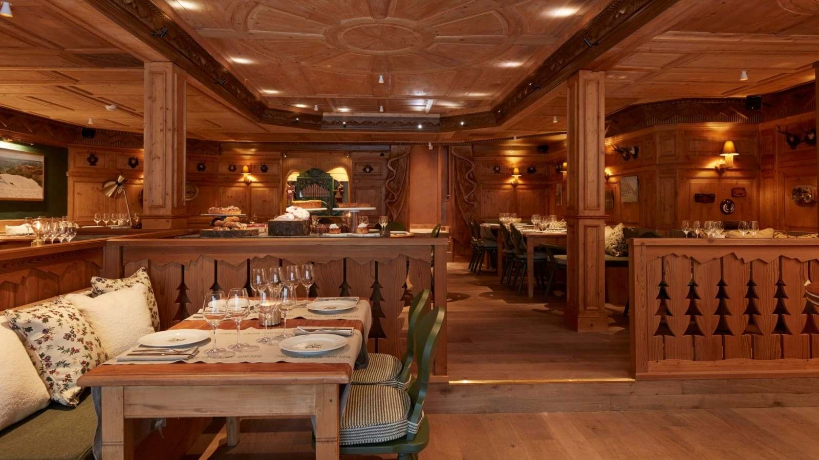 Wood-paneled dining room with banquet seating and hand-carved details