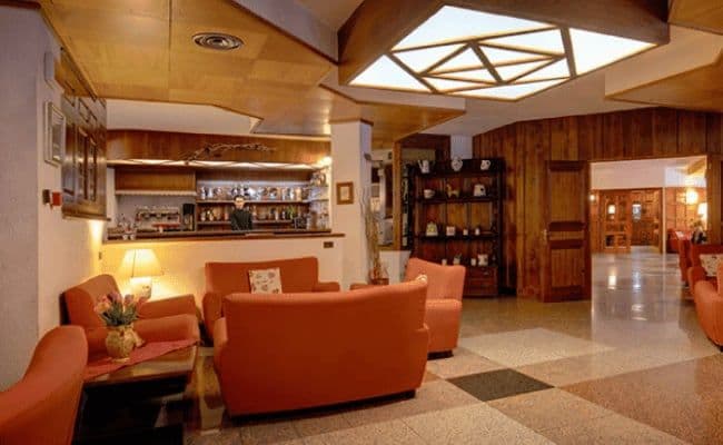 Lounge area featuring integrated wet bar and geometric wood ceiling