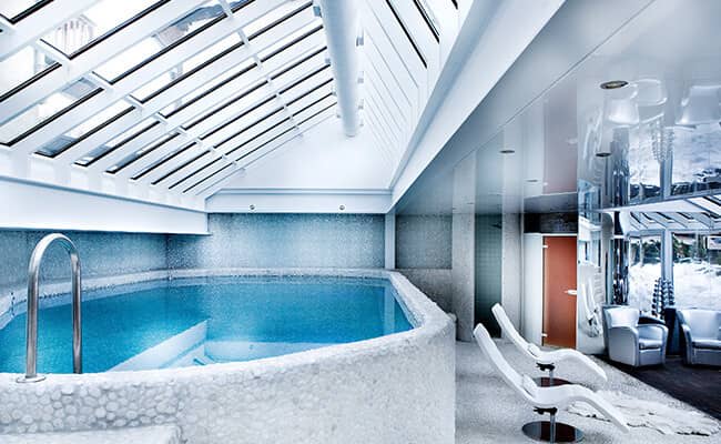 Indoor pool with large skylight and adjacent sauna access