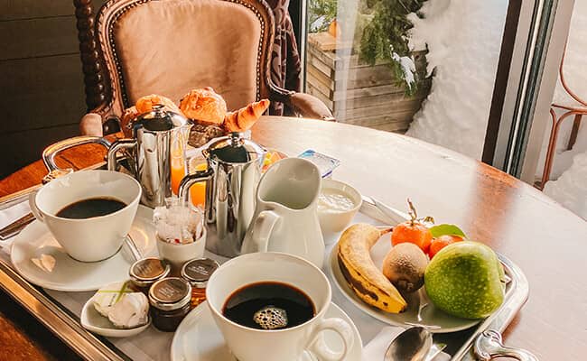 Breakfast for two served at dining table with snowy balcony view