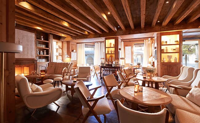 Lounge with wood-beamed ceiling, fireplace, and seating for over 15 guests