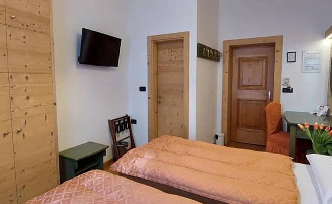 Guest bedroom with twin beds, wall-mounted TV, and built-in wardrobe