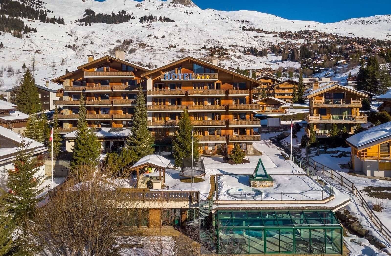 Ski-in, ski-out chalet exterior with private balconies and glass-enclosed indoor pool