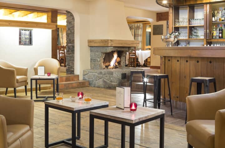 Lounge area with stone fireplace, cocktail bar, and armchair seating