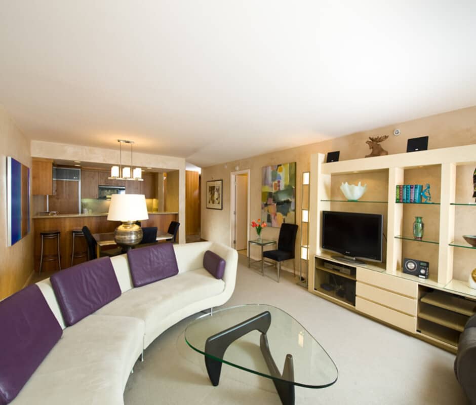 Living room with curved sectional and view into open kitchen