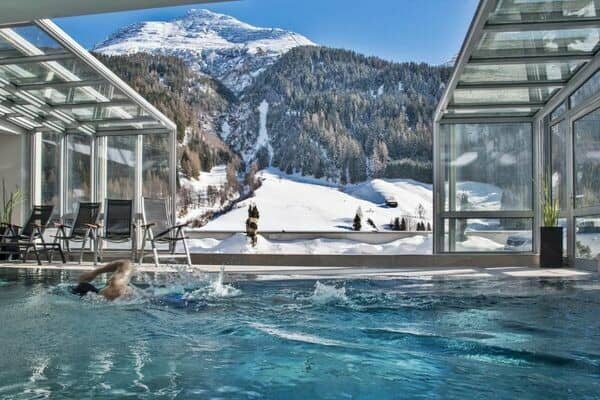 Indoor heated pool with retractable glass roof and mountain views