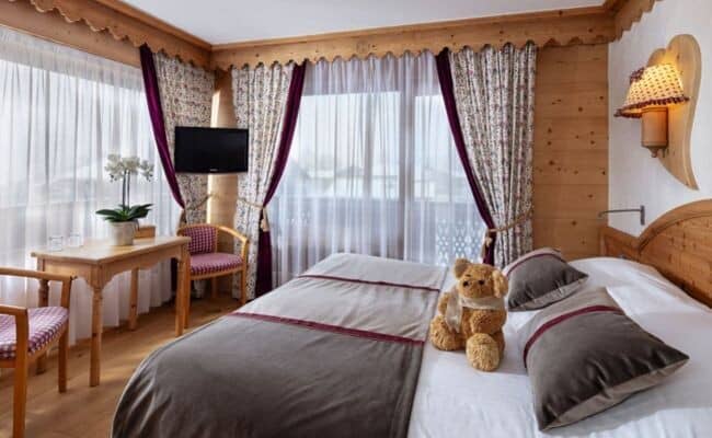 Bedroom with king bed and small desk; Alpine wood trim