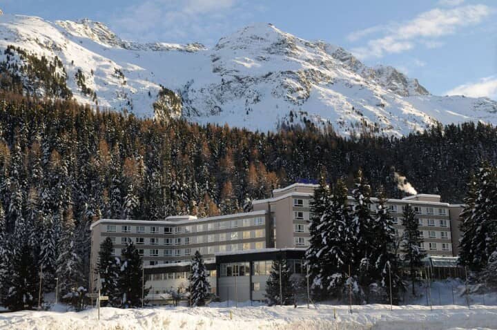 Ski-in/ski-out hotel exterior with alpine mountain backdrop