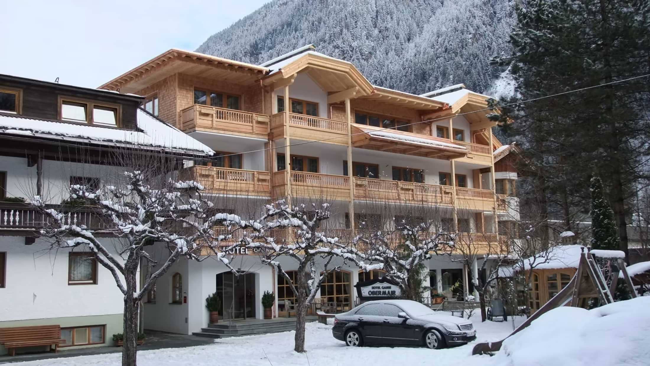 Chalet exterior with private balconies and snow-covered mountain backdrop