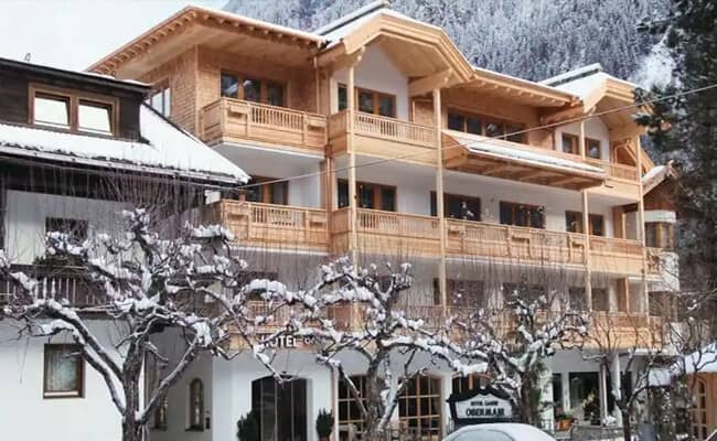 Chalet exterior with private timber balconies and mountain forest backdrop