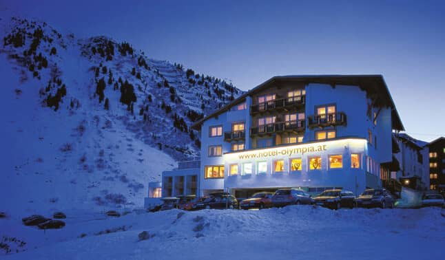 Ski-in/ski-out hotel exterior with on-site parking and mountain backdrop