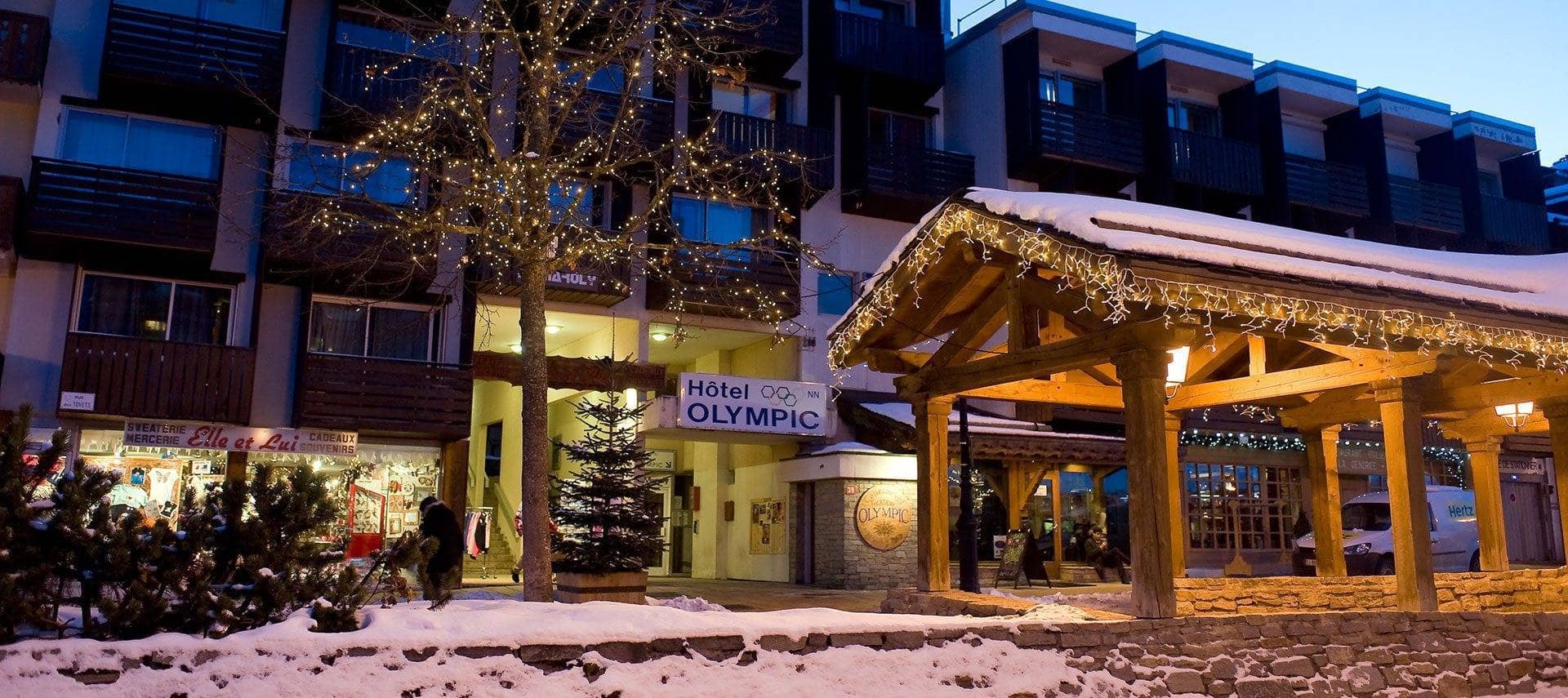 Hotel Olympic exterior with ground-floor shops and covered timber walkway