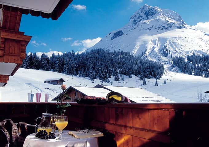 Private wooden balcony with mountain peak views and bistro seating