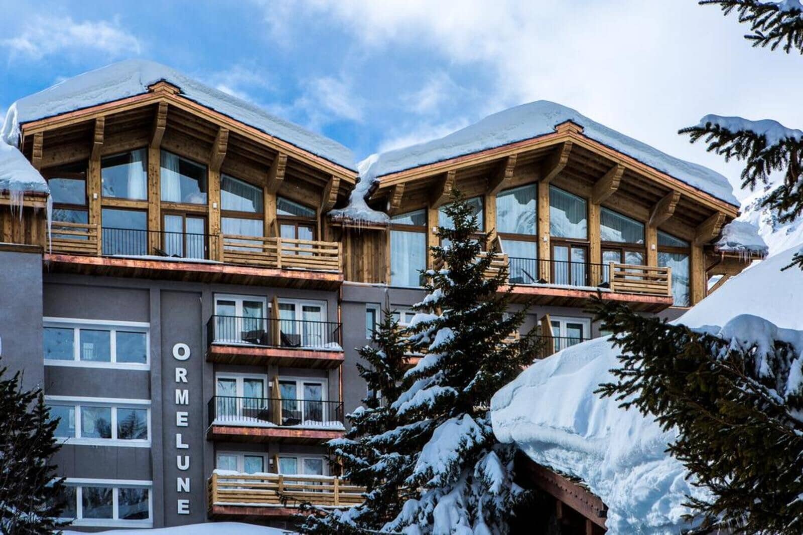 Ski-in/ski-out hotel exterior with private balconies and floor-to-ceiling windows