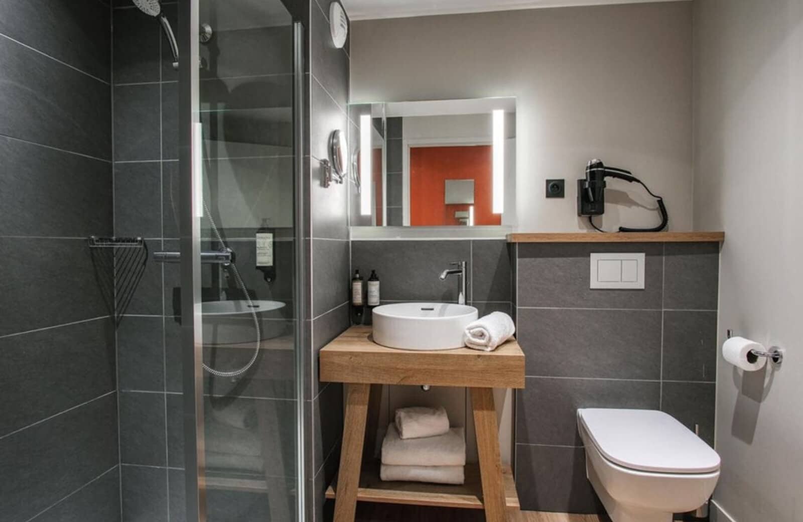 Bathroom with walk-in glass shower and integrated mirror lighting