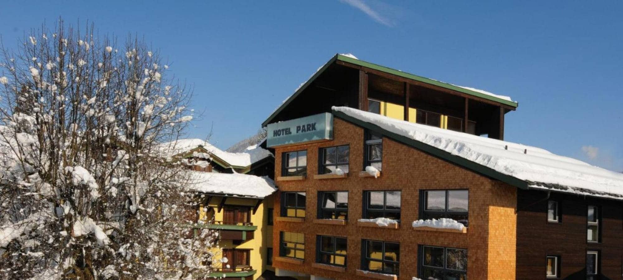 Hotel exterior featuring shingle siding and private balconies with snow-covered roofs