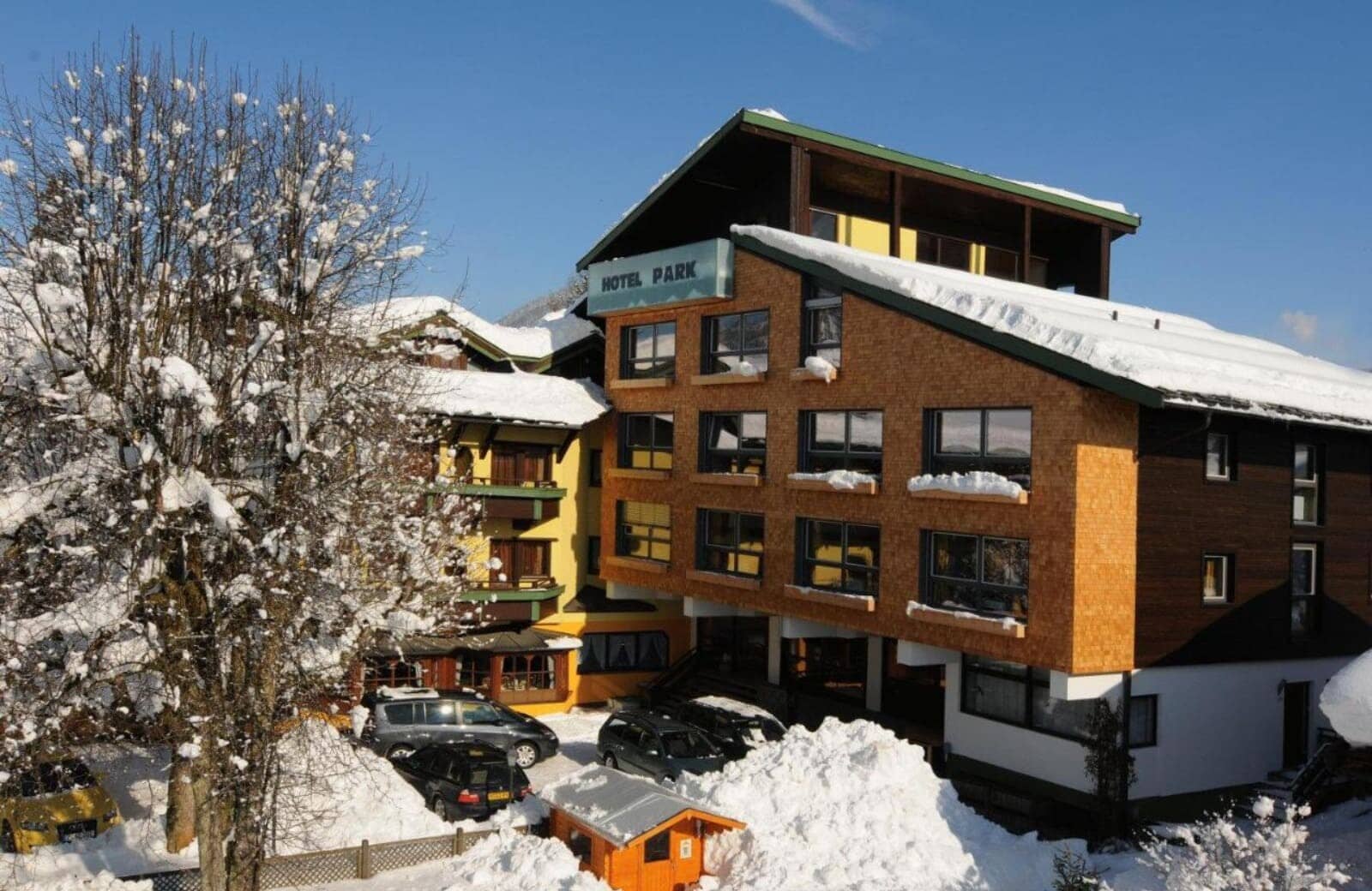 Hotel exterior with on-site parking and snowy mountain setting