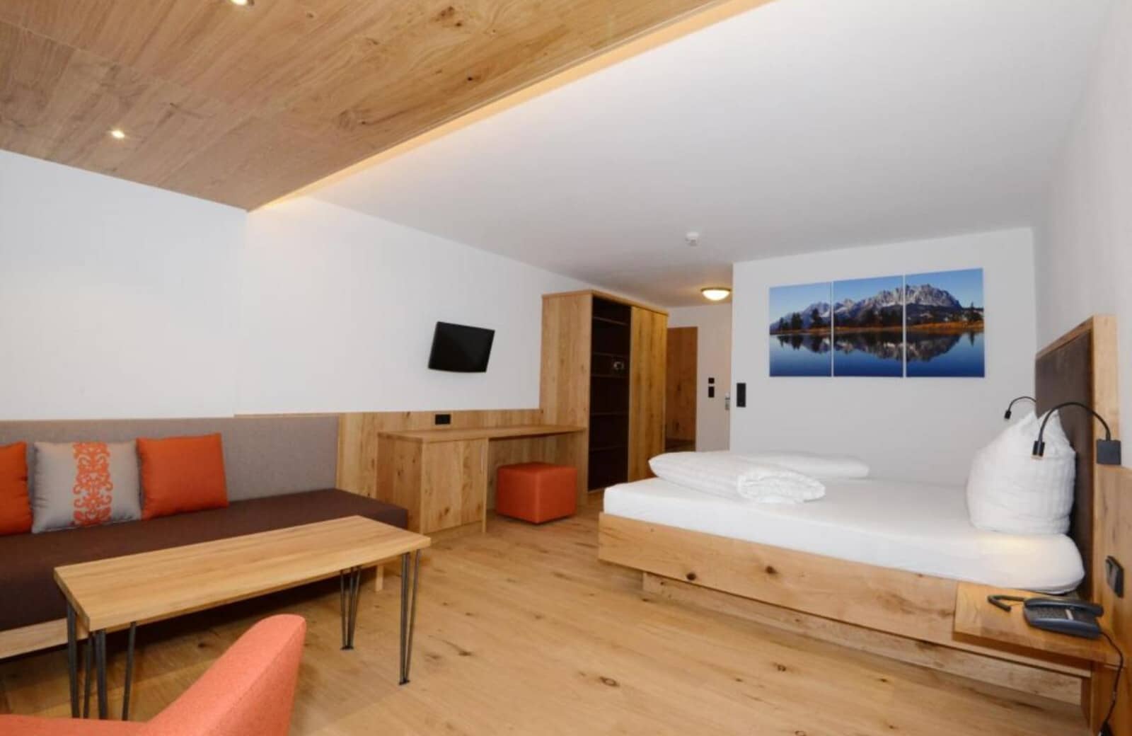 Studio suite with queen bed, sofa seating, and built-in desk