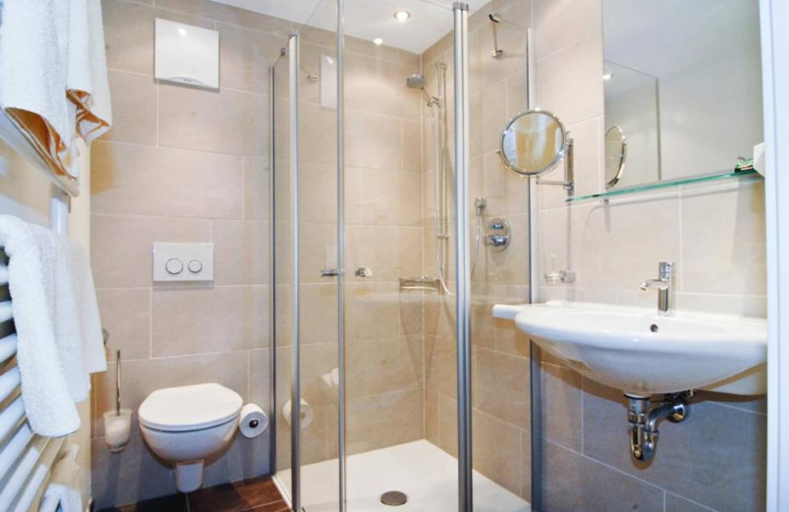 Bathroom with walk-in glass shower and wall-mounted towel warmer