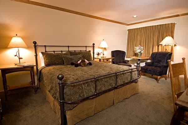 Bedroom with king bed and reading nook featuring two armchairs