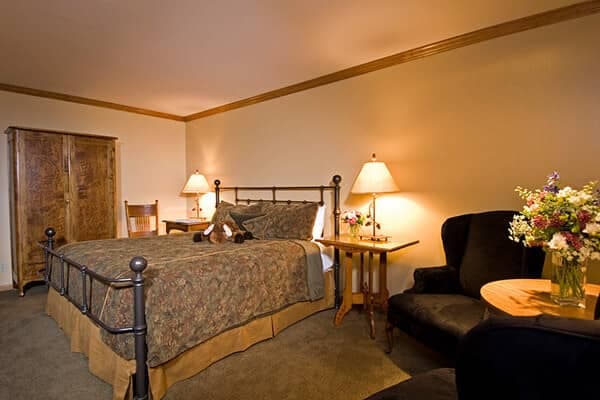 Guest bedroom with queen bed, armoire, and reading nook