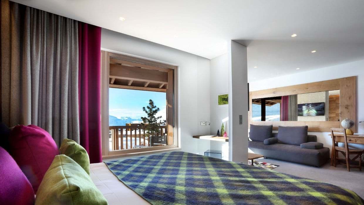 Primary bedroom with king bed and balcony; attached sitting area with desk