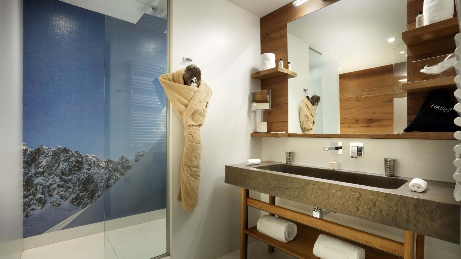 Bathroom with stone trough sink and walk-in shower featuring mountain mural