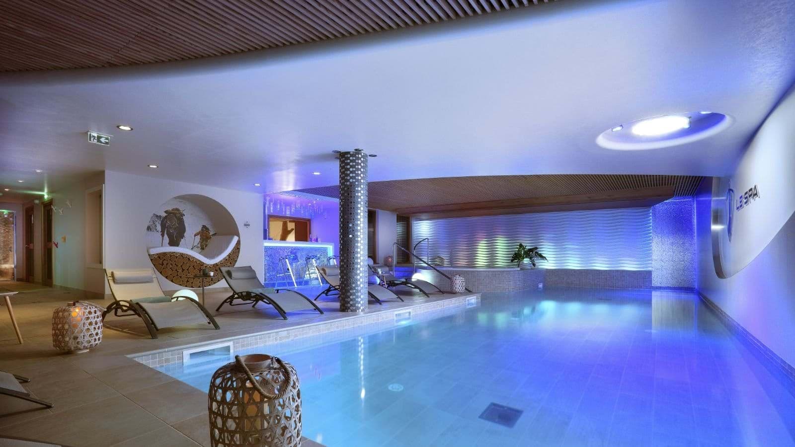 Indoor pool with poolside lounge chairs and refreshment bar