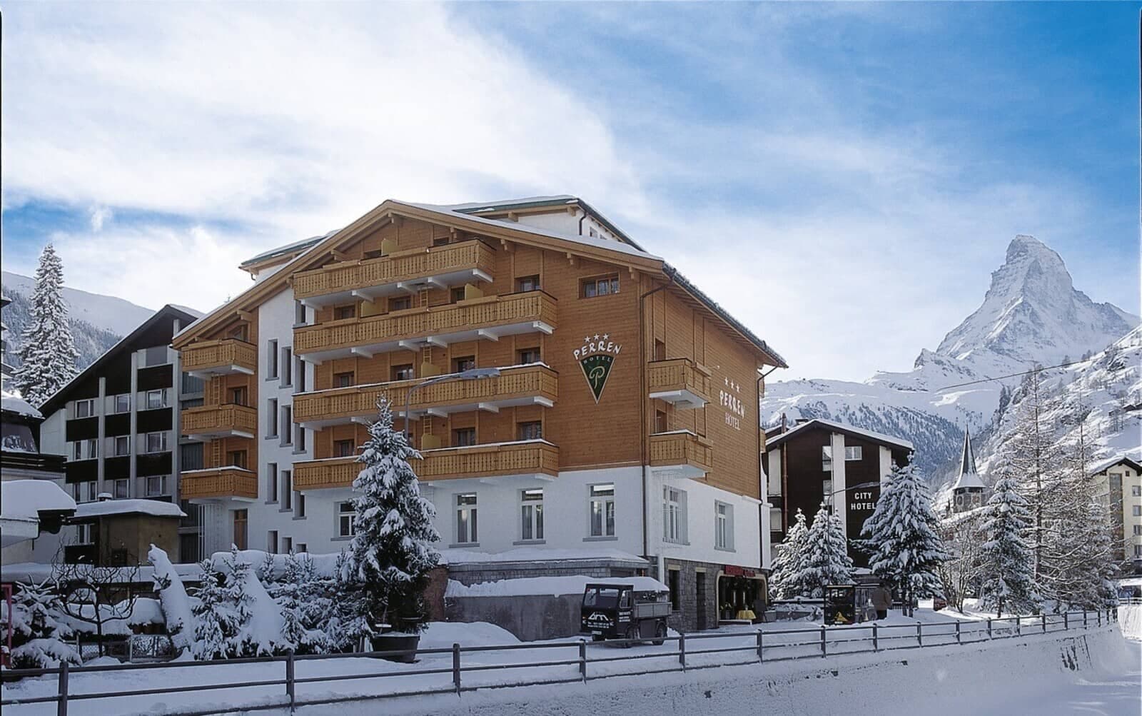 Hotel Perren exterior featuring private balconies with Matterhorn mountain views